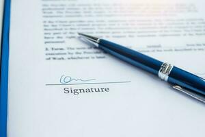 signature with pen on contract documents. Contract agreement, approve, law and deal concepts photo