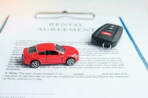 contract document with car and remote key. buy and sale, insurance, rental and contract agreement concepts photo