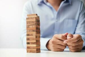 Businessman hand placing or pulling wooden block on the tower. Business planning, Risk Management, Solution and strategy Concepts photo