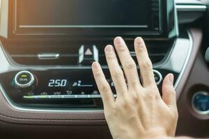 mano de mujer comprobando el flujo de aire durante la conducción del coche en la carretera, sistema de refrigeración del aire acondicionado dentro del coche. concepto de ajuste, temperatura y transporte foto