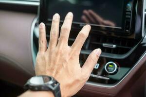 hombre mano comprobación el aire fluido durante conducción coche en el camino, aire acondicionador enfriamiento sistema dentro el coche. ajustar, temperatura y transporte concepto foto