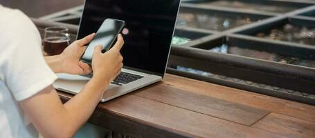 Casual Businesswoman using smartphone and laptop, freelance woman typing keyboard computer notebook in cafe or modern office. technology, digital online and network concept photo