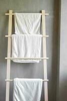 Closeup clean bathrobe and towel hanging in wooden wardrobe at luxury hotel. Relax and travel concept photo