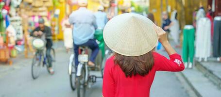 happy woman wearing Ao Dai Vietnamese dress, asian traveler sightseeing at Hoi An ancient town in central Vietnam. landmark and popular for tourist attractions. Vietnam and Southeast travel concept photo