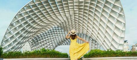 Woman Traveler with yellow dress visiting in Da Nang city. Tourist sightseeing the city building. Landmark and popular for tourist attraction. Vietnam and Southeast Asia travel concept photo