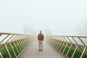 man Traveler sightseeing Golden bridge at the top of the Ba Na Hills. Landmark and popular. Vietnam and Southeast Asia travel concept photo