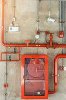 Fire extinguisher and water pump system on the wall, powerful emergency equipment for apartment and hotel photo