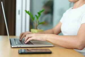 Casual Businesswoman using laptop, freelance woman typing keyboard computer notebook in cafe or modern office. technology, digital online and network concept photo