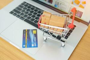 Boxes with credit card on a laptop computer. online shopping, Marketplace platform website, technology, ecommerce, shipping delivery, logistics and online payment concepts photo