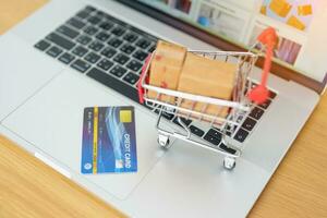 Boxes with credit card on a laptop computer. online shopping, Marketplace platform website, technology, ecommerce, shipping delivery, logistics and online payment concepts photo