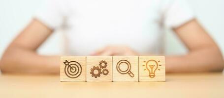 dartboard, Gear, magnifying and Lightbulb icon block on table. business planning process, goal, strategy, target, mission, action, research, teamwork and idea concept photo