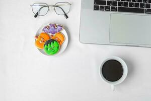 Halloween Cookies,  hot coffee and computer laptop on white background. Happy Halloween, online shopping, Hello October, fall autumn, Festive, party and holiday concept photo