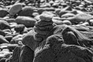 interesting tower made of stones arranged on the shore of the ocean on a warm summer's day photo