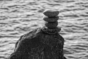 interesting tower made of stones arranged on the shore of the ocean on a warm summer's day photo