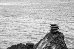 interesting tower made of stones arranged on the shore of the ocean on a warm summer's day photo