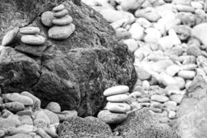 interesting tower made of stones arranged on the shore of the ocean on a warm summer's day photo