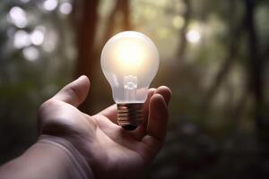 Hand holding light bulb on nature background, Business and innovation concept. photo
