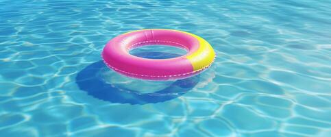 Pink Swimming Pool Ring Float on Blue Water. Summer Background. photo