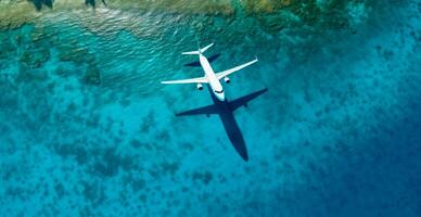 Top down view of white plane flying over blue sea, ocean, travel, vacation concept - image photo