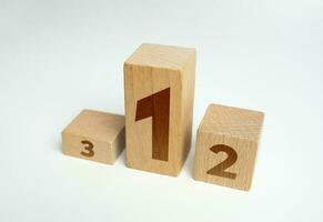 Three first places in the competition. Stand podium made of wooden blocks. Summing up the results of contest. Evaluation of the best ideas or products after review. Competition concept. photo