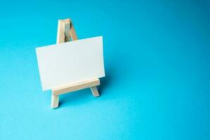 An easel with a clean canvas on a blue background. Delivery of information. Business and education. Reports and statistics. Art. photo