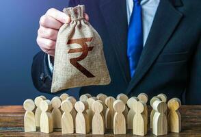 Businessman holds out a indian rupee money bag to the crowd. Compensation payments. Official. Staff maintenance. Financial support. Tax collection. Providing money, paying salaries and grants. photo