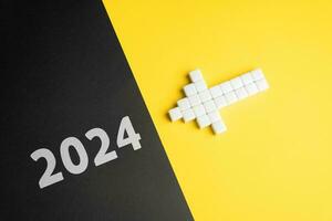 The arrow points to 2024. The beginning of a new year. Embracing new trends, making forecasts, setting plans for the upcoming year. Reflecting on past achievements and experiences, looking forward photo