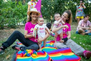 Two women in love in the park with their twin daughters photo