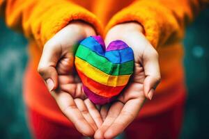 unrecognizable person hands holding LGBTQ flag heart. photo