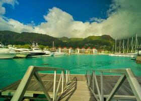 unión cósmica yates y barcos a Edén isla centro de deportes acuáticos con nuevo edificio villas a el atrás, ver de mahe isla, lozano montaña, seychelles foto