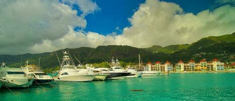 Docking yachts and boats at eden island marina with new building villas at the back, view of Mahe island, lush mountain, Seychelles photo