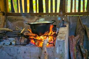 Authentic and traditional way of cooking the creole food in Seychelles, on  cast iron pot in direct wooden flames, Mahe Seychelles. photo