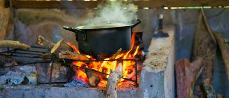 Authentic and traditional way of cooking the creole food in Seychelles, on  cast iron pot in direct wooden flames, Mahe Seychelles. photo