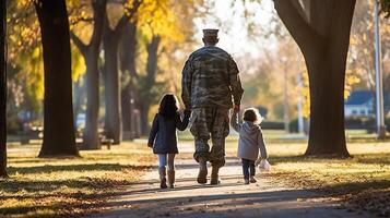 Military father walking with his two daughters in the park, back view. . photo