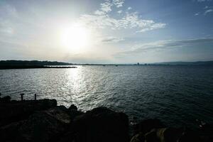 Sunset on the sea with rocks and blue sky in the background. photo