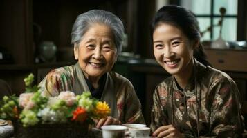 Asian japanese grandmother and granddaughter sitting at table in living room with tea. Generative AI. photo
