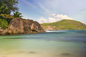 25 second long exposure of beach with rock boulders and coconut palm trees, Mahe Seychelles photo