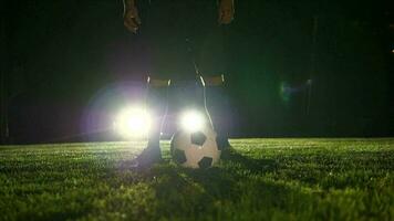 Sports person training with soccer ball on soccer field in slow motion video