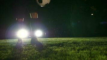 Soccer player playing with soccer ball on field at night video