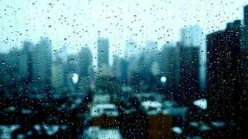 pluie gouttes verser vers le bas sur fenêtre verre avec Urbain ville horizon vue sur une pluvieux temps journée video