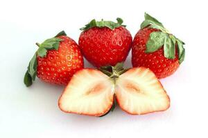 Whole and sliced piece strawberry fruit isolated on white paper background. photo