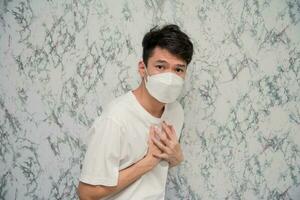 Man puts on a face mask chest pain isolated on White background,pandemic and social distancing concept.Covid-19 photo