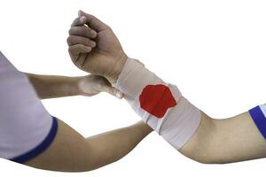 First aid training to wrap the wound around  arm with bandage on arm to stop the bleeding photo