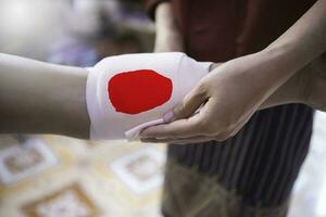 First aid training to wrap the wound around  arm with bandage on arm to stop the bleeding photo