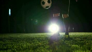 fútbol jugador jugando con fútbol pelota en campo a noche video