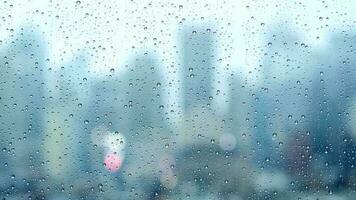 Regen Tropfen Gießen Nieder auf Fenster Glas mit städtisch Stadt Horizont Aussicht auf ein regnerisch Wetter Tag video