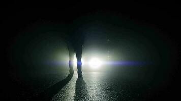 Person walking outside on dark spooky street at night video