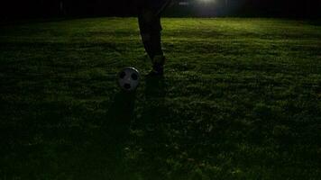 Soccer player playing with soccer ball on field at night video