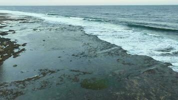 aereo Visualizza di Basso marea spiaggia e mare con rocce nel Jogia, Indonesia. video