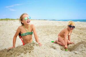 Children play with sand on beach. photo